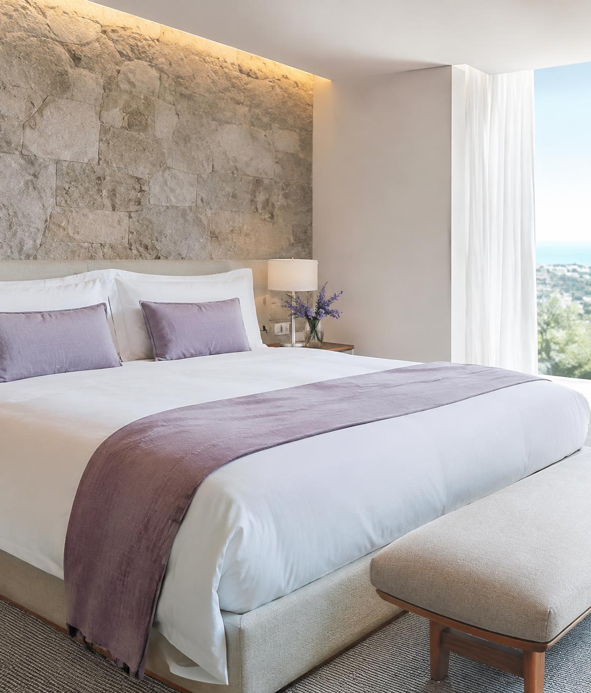 Serene bedroom with stone wall and lavender accents